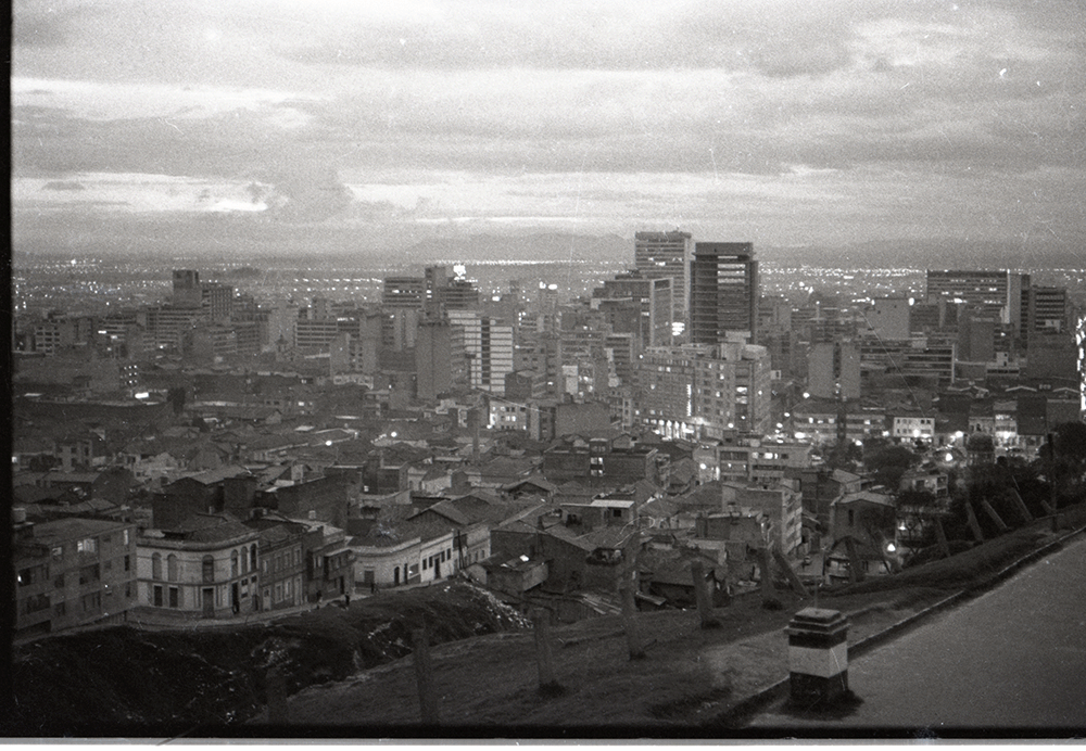 Panorámica de Bogotá, 1964. Caicedo mantuvo siempre una fascinación profunda por la ciudad, sus ritmos y las diversas formas en como informaba a sus habitantes. En su fotografía, Bogotá, más que un trasfondo, deviene la verdadera protagonista en la búsqueda de un mapeo cognitivo que dé cuenta de la relación entre su espacialidad y las condiciones de vida de sus habitantes.