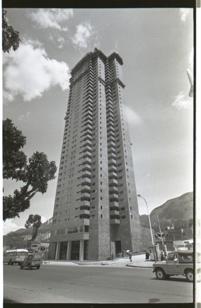 Primera torre del antiguo Hotel Hilton, 14 de noviembre, 1969. caballo en primer plano riendo. El contraste entre los intentos de construcción de una metrópolis moderna y los vestigios omnipresentes de las dificultades que los bogotanos tenían realmente de acceder a ella, informan una parte importante del registro fotográfico urbano de Caicedo.