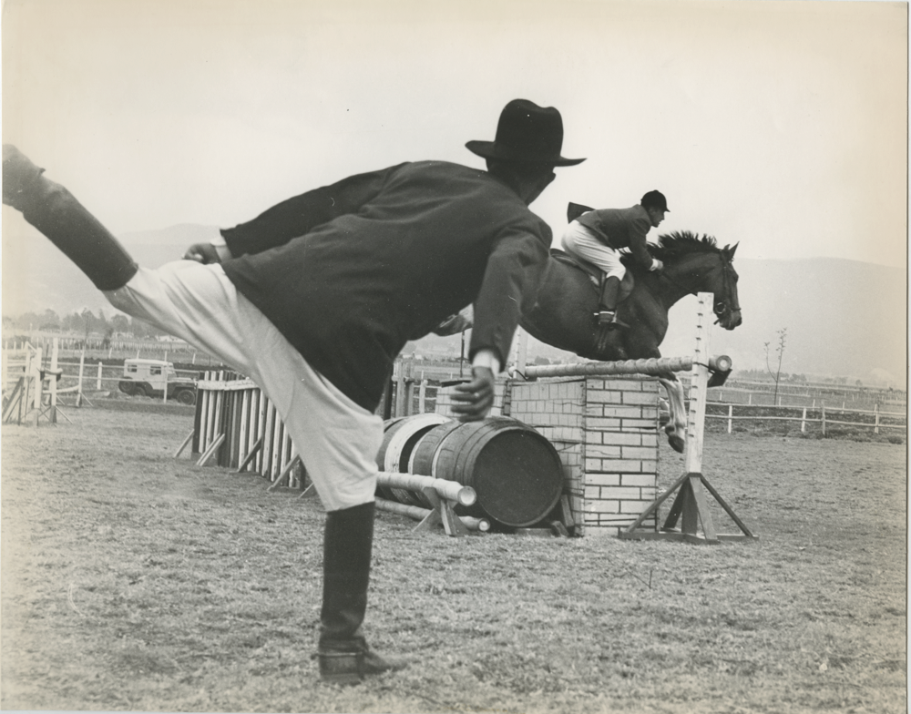 Jinete saltando en caballo y jinete en tierra. Bogotá, 1975. Las prácticas ecuestres fueron un motivo central en la historia de la fotografía, y Caicedo no fue ajeno a este tipo de registro. Esta imagen, es emblemática de la forma en que Caicedo se aproximó en repetidas ocasiones a la fotográfica ecuestre: al tiempo en procura de la captura del momento decisivo que condensara el movimiento, y del gesto jocoso o incluso irónico.