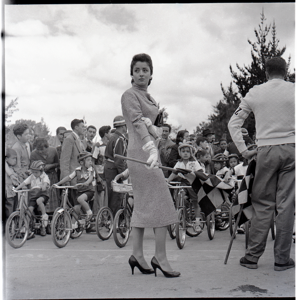 Yolanda Pulecio en evento de ciclismo para niños, posiblemente en Bogotá. Circa 1958.
Para esa fecha, Yolanda Pulecio (1939-) había participado en el Concurso Nacional de Belleza. En 1958 fundó el Albergue Infantil de Bogotá. Contrajo matrimonio con Gabriel Betancourt al año siguiente. Fue congresista y diplomática. Estuvo casada con Gabriel Betancourt (1918-2002), político colombiano que fundó el ICETEX. Ingrid Betancourt es hija de ambos.

Tomado de www.unodc.org y Wikipedia, entradas Yolanda Pulecio y Gabriel Betancourt. Consultadas el 13 de junio, 2023.