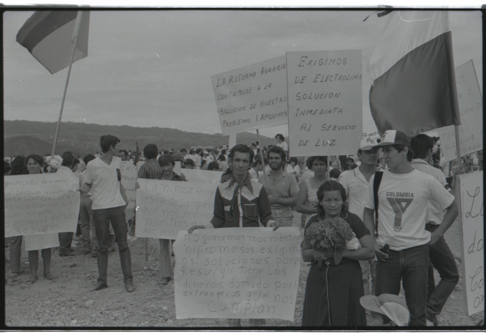 Camposanto de Armero, después de la avalancha causada por la erupción del volcán Nevado del Ruiz el 13 de noviembre de 1985. Llama la atención la manifestación de habitantes exigiendo al gobierno nacional llevar a cabo una reforma agraria, según se lee en uno de los carteles.